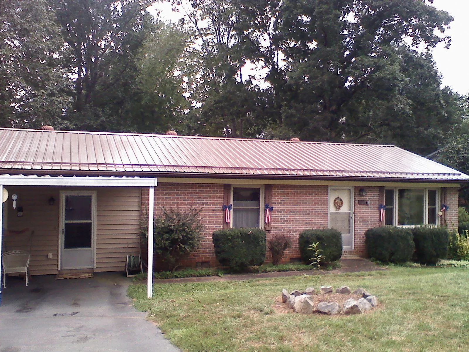 Bronze metal roof and carport on a brick ranch home — Roof Repair work by our crew in Ionia